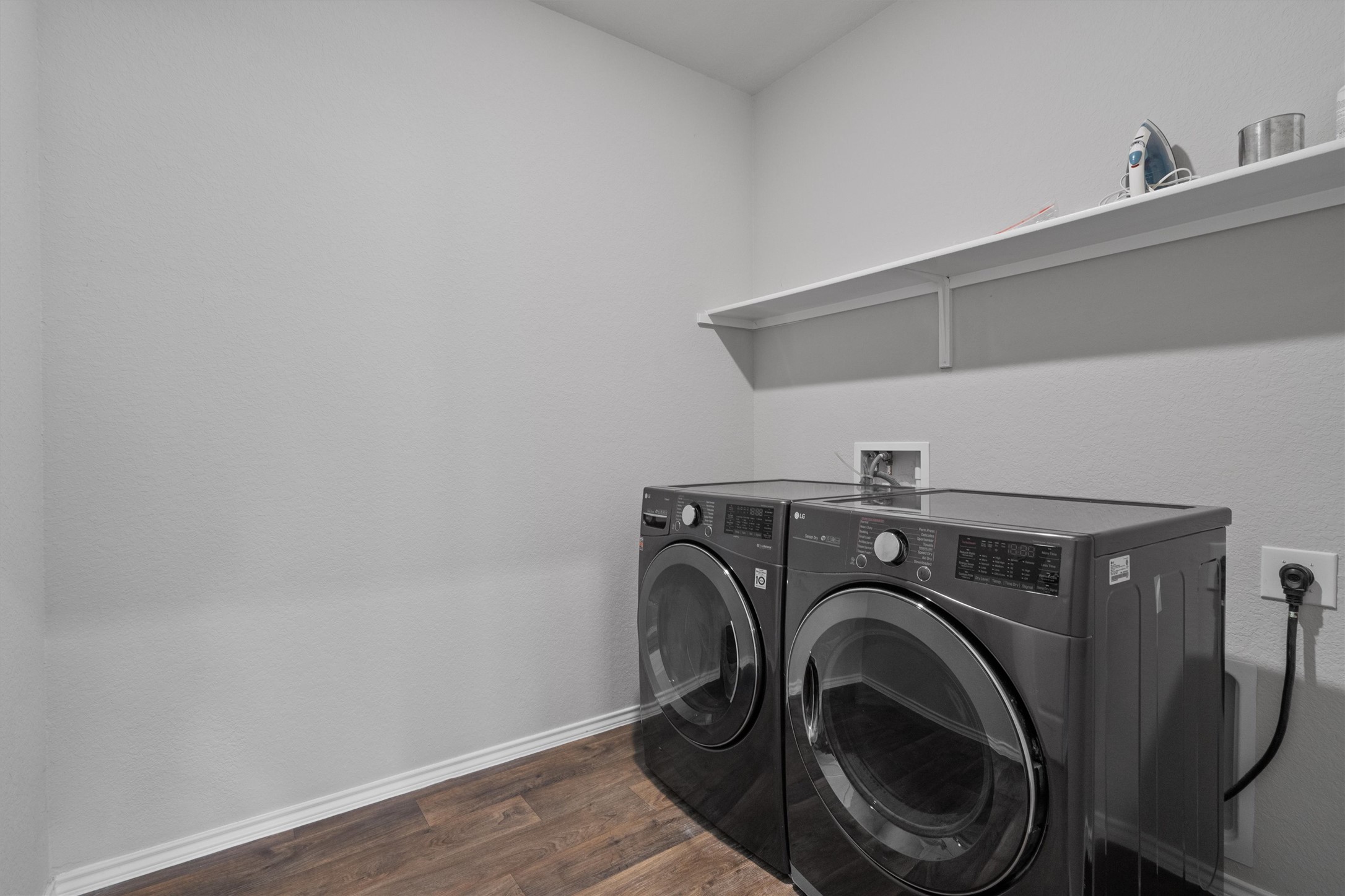 6121 Ronee Leah Drive Austin, TX 78724 - Photo 28 of 30 Streamlined laundry room with functional shelving and modern appliances for everyday convenience.