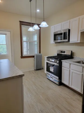 a kitchen with stainless steel appliances granite countertop a stove a sink and a microwave