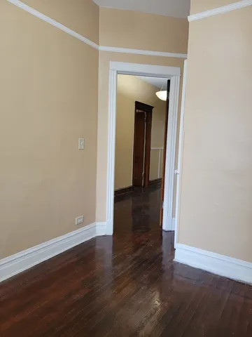 an empty room with wooden floor and closet