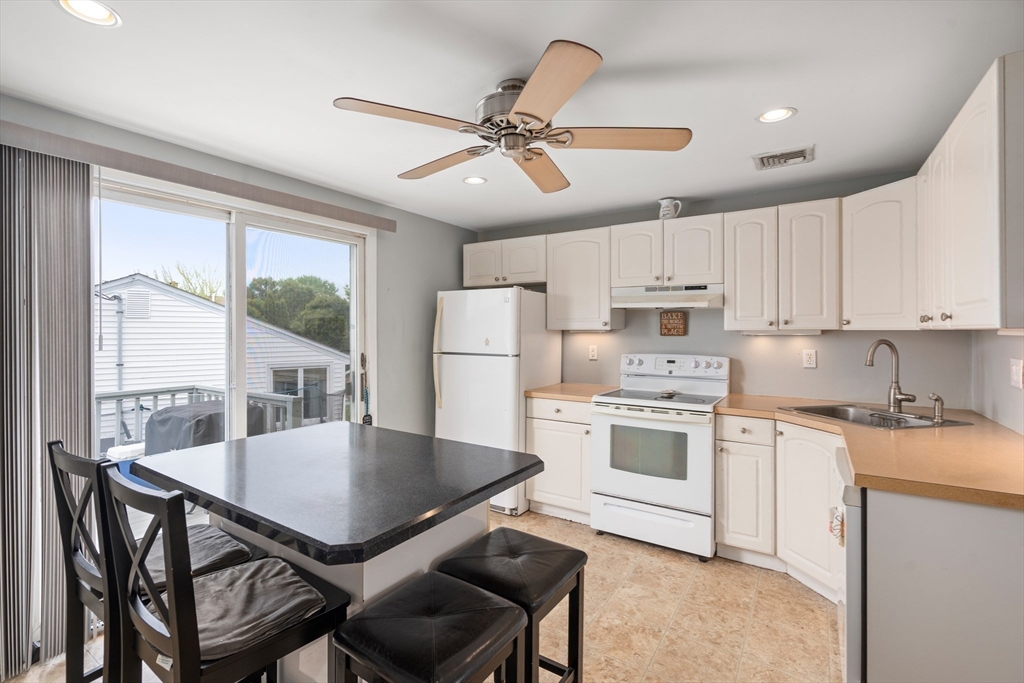 292 Rumney Road Revere, MA 02151 - Photo 8 of 24 a kitchen with a table chairs microwave and cabinets
