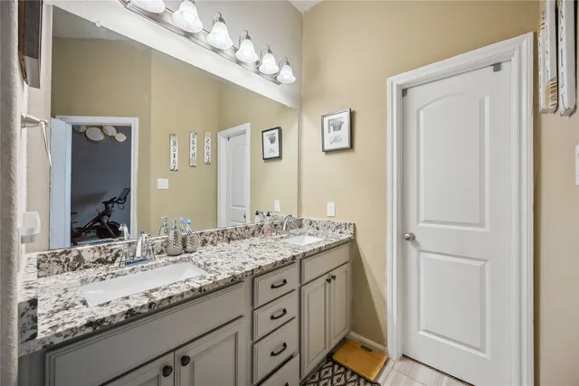 a bathroom with a granite countertop sink a mirror and a shower