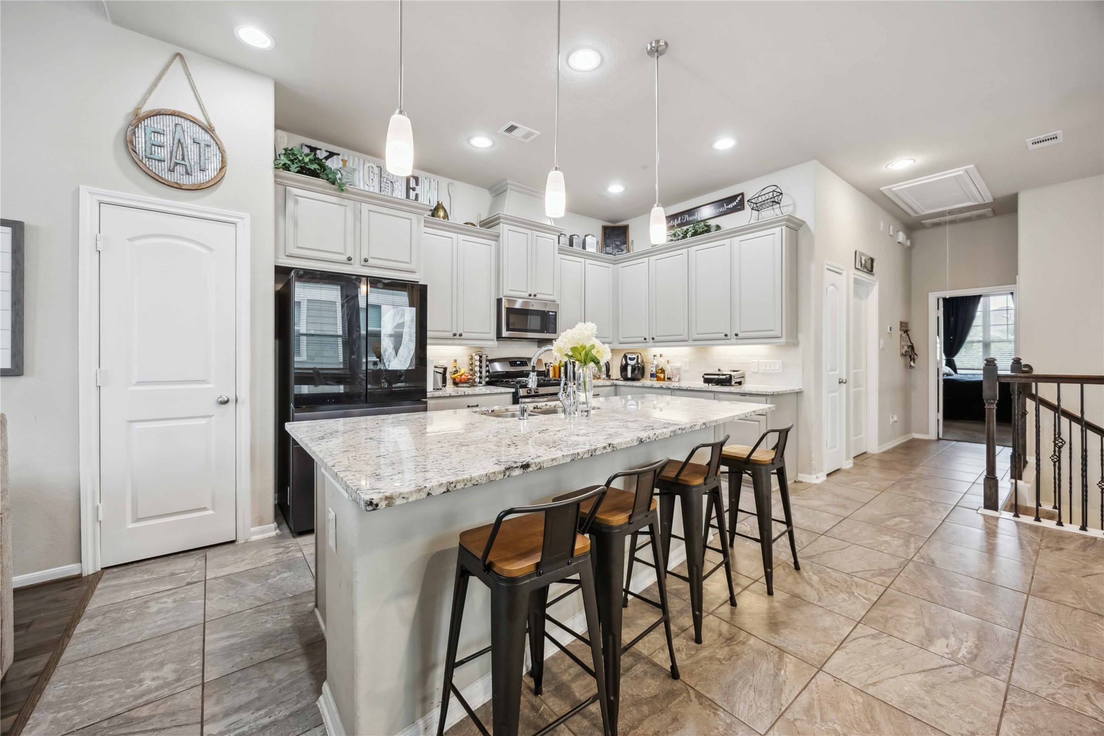 12419 Alora Bluff Trail Humble, TX 77346 - Photo 9 of 28 a kitchen with stainless steel appliances kitchen island granite countertop a refrigerator and a stove top oven
