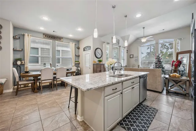a kitchen with counter space appliances a sink and a living room view