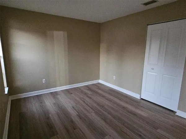 a view of an empty room with wooden floor