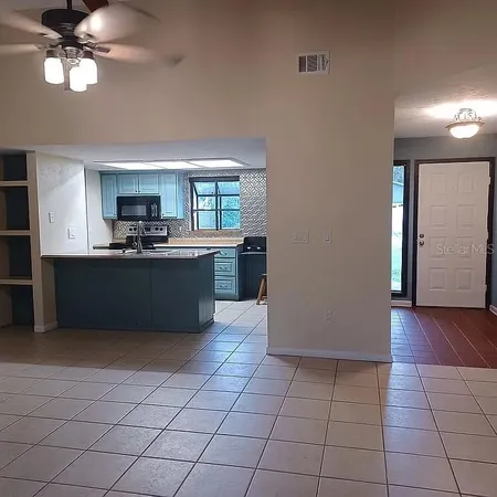 a kitchen with stainless steel appliances a sink a stove a refrigerator cabinets and a window