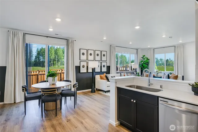 a kitchen with a table chairs and wooden floor