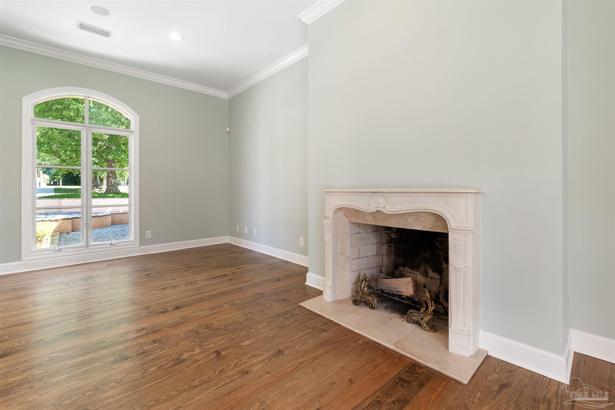 1725 E Lane Pensacola, FL 32501 - Photo 11 of 72 a view of an empty room with wooden floor and a fireplace