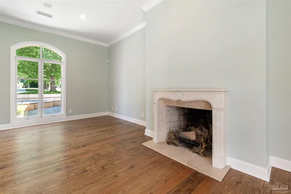 a view of a hallway with wooden floor and windows