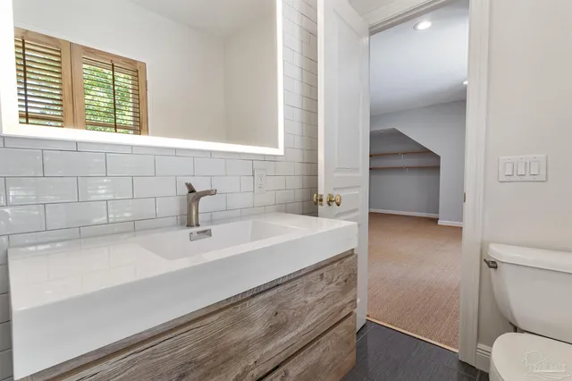 a view of a patio with table and chairs under an umbrella with large trees