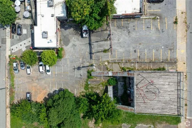 an aerial view of a house with a yard and large tree
