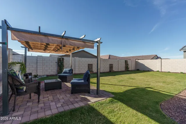 a view of a patio with table and chairs under an umbrella