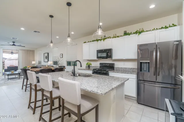 a kitchen with stainless steel appliances granite countertop a kitchen island a stove a table and chairs