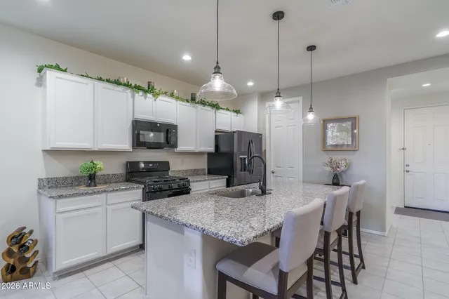 a kitchen with granite countertop a table chairs microwave and cabinets