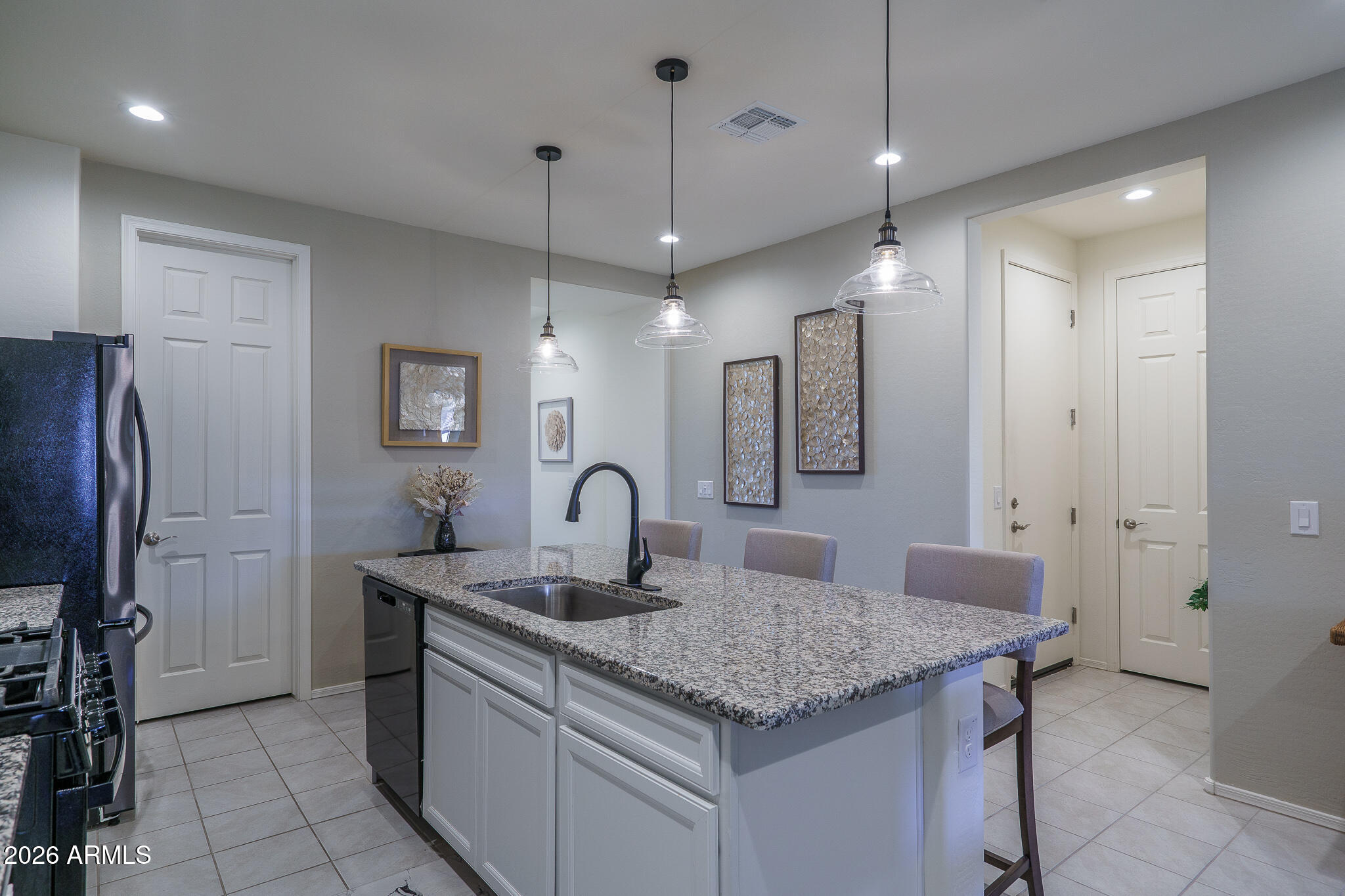 17851 West Red Fox Road Surprise, AZ 85387 - Photo 4 of 42 a kitchen with center island a sink stainless steel appliances and cabinets