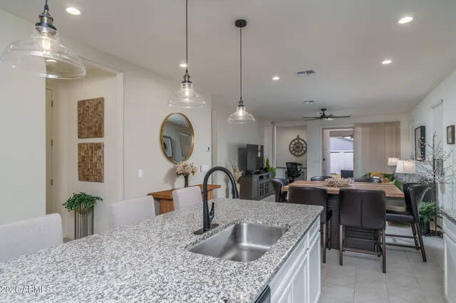 a kitchen with granite countertop a sink a counter top space and living room view
