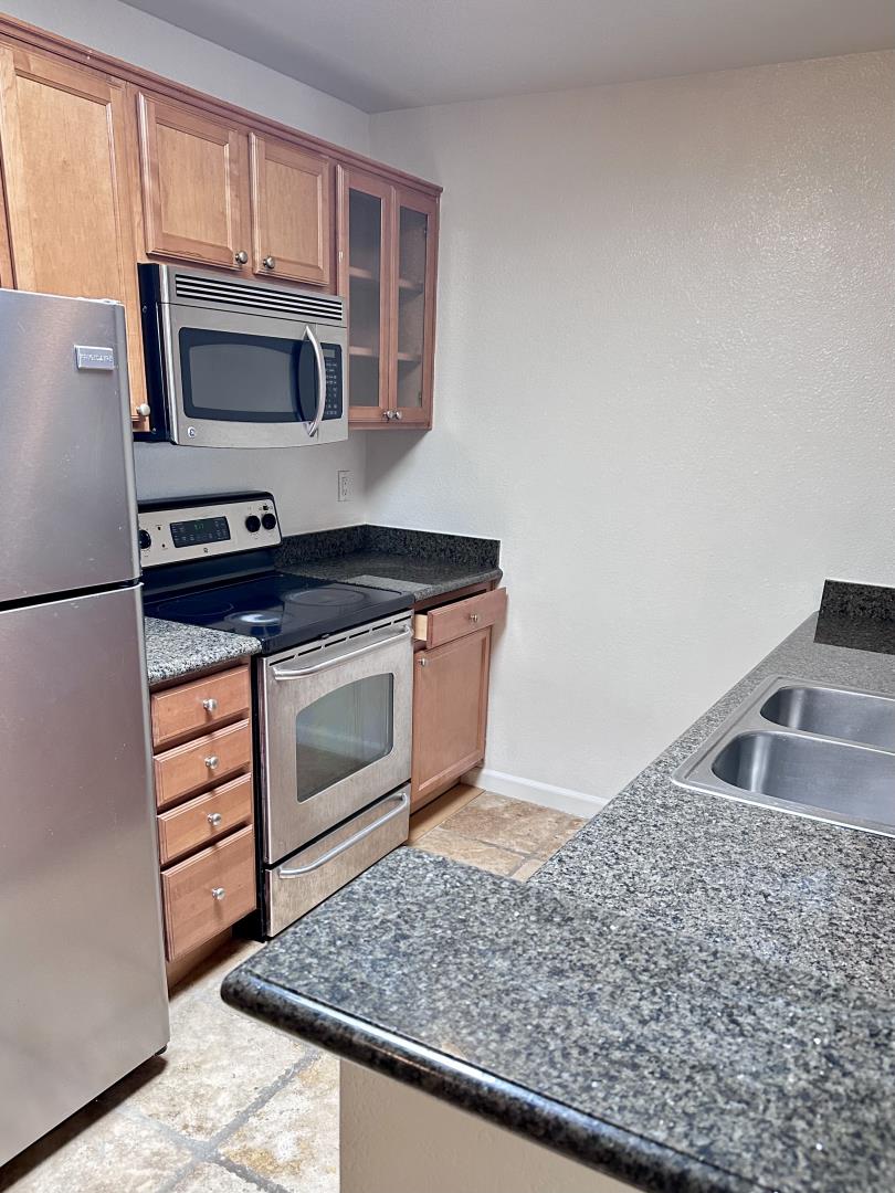 436 Dempsey Road, Unit 238 Milpitas, CA 95035 - Photo 2 of 16 a kitchen with granite countertop a stove and a sink