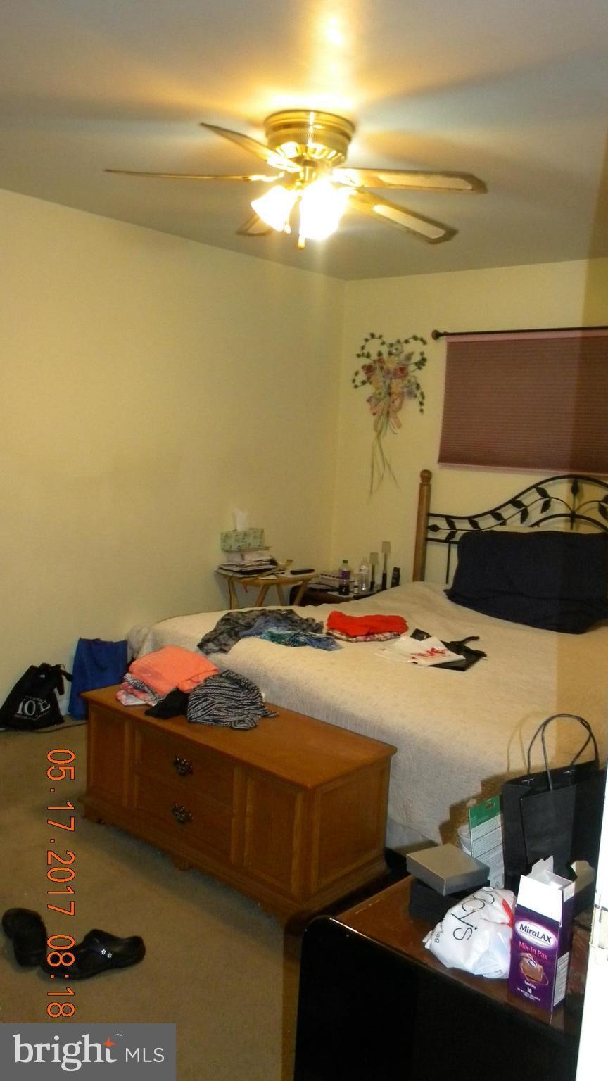 917 Prestwood Road Baltimore, MD 21228 - Photo 17 of 18 a bedroom with a bed and a chandelier