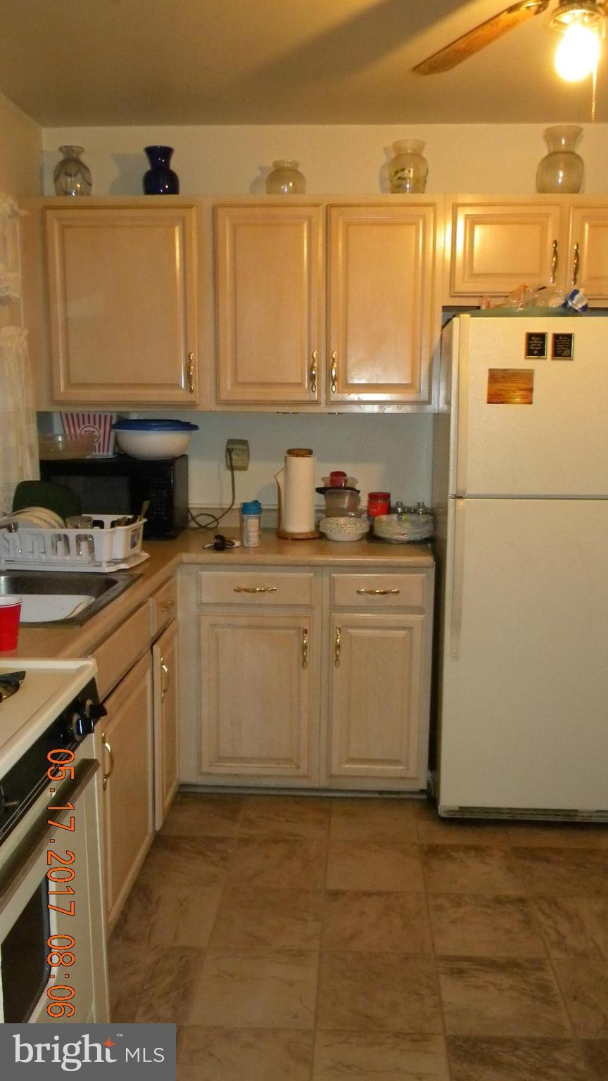 917 Prestwood Road Baltimore, MD 21228 - Photo 5 of 18 a kitchen with stainless steel appliances a sink a stove a microwave a sink and cabinets