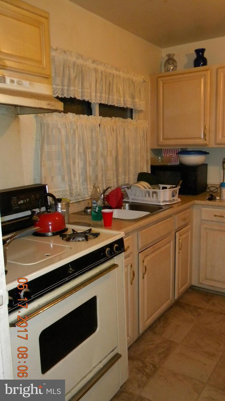917 Prestwood Road Baltimore, MD 21228 - Photo 6 of 18 a kitchen with a sink stove and cabinets