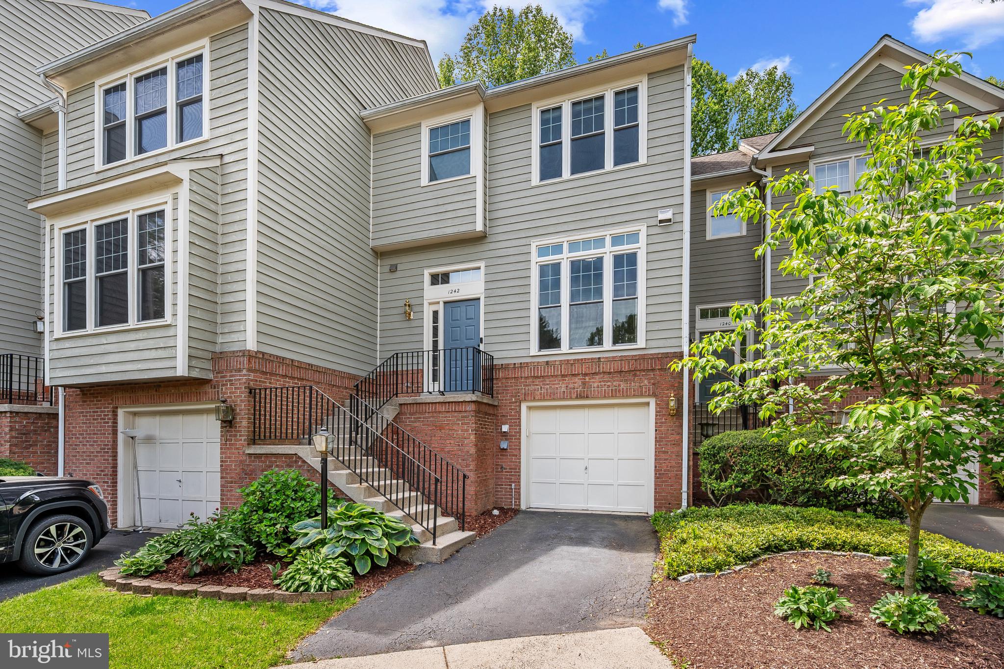 1242 Weatherstone Court Reston, VA 20194 - Photo 2 of 40 a front view of a house with a yard and garage