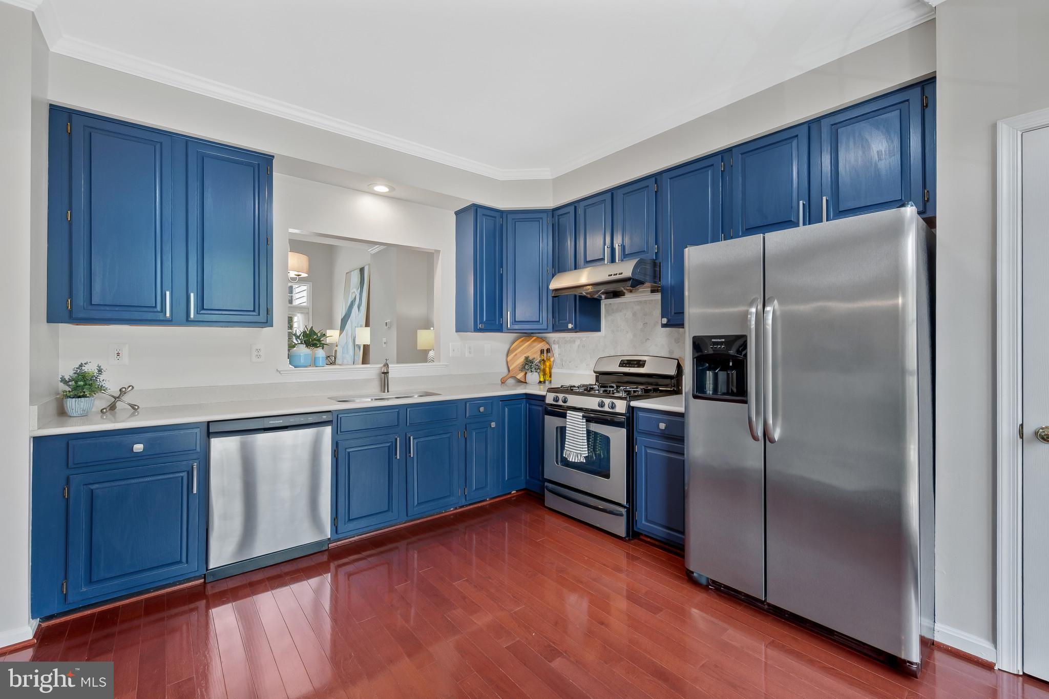 1242 Weatherstone Court Reston, VA 20194 - Photo 7 of 40 a kitchen with a refrigerator sink and wooden cabinets