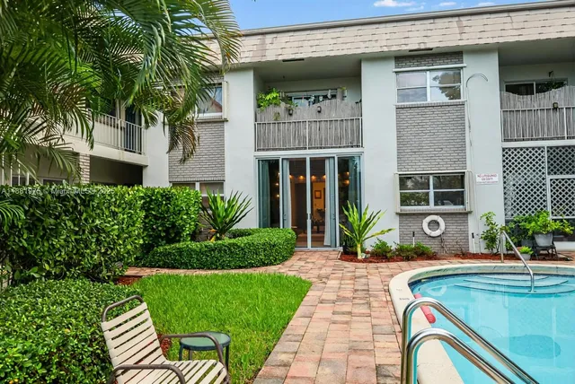 a front view of a house with a yard potted plants and a table