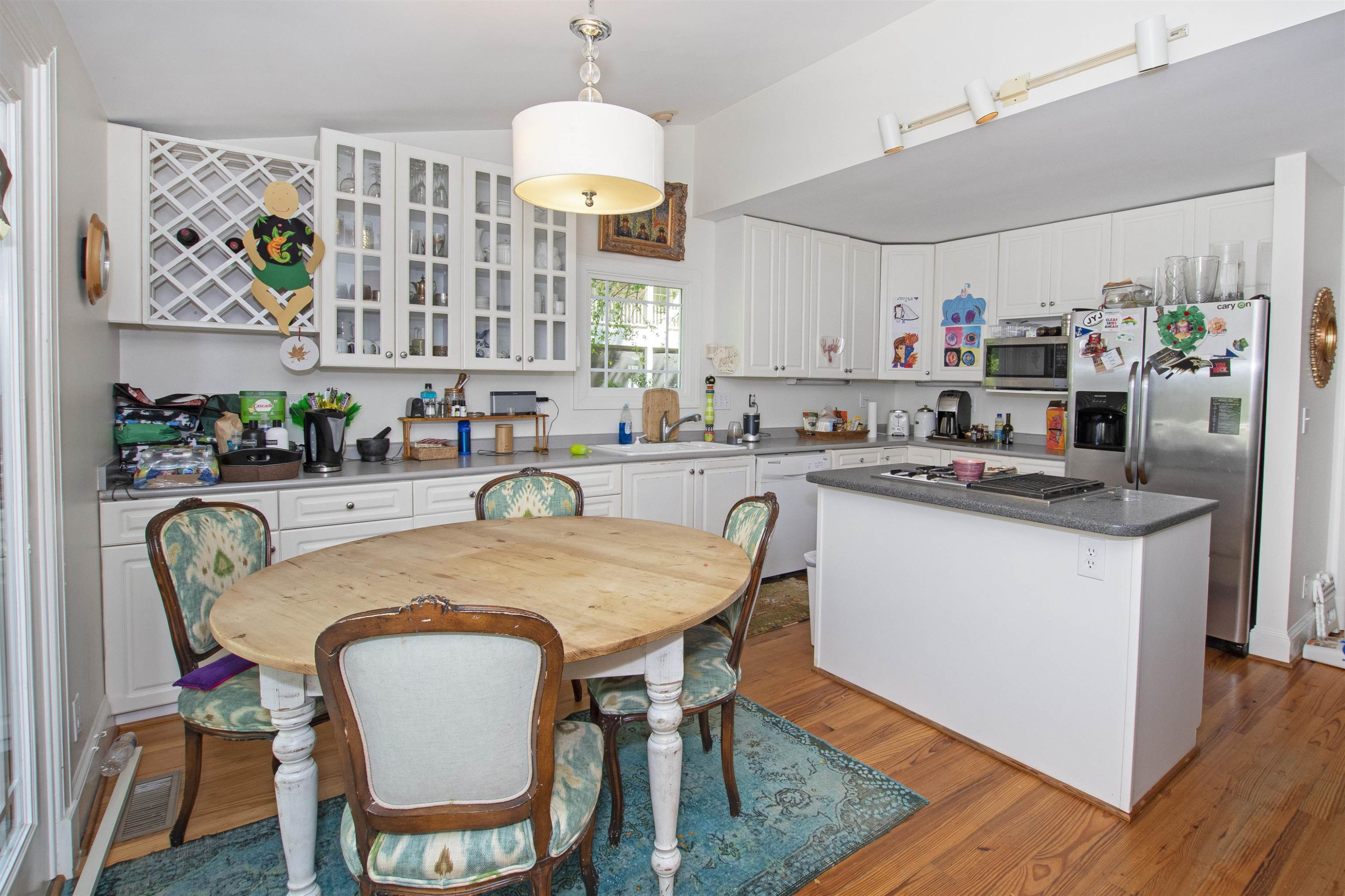 2610 Dover Road Raleigh, NC 27608 - Photo 12 of 20 a kitchen with a dining table chairs sink and white cabinets
