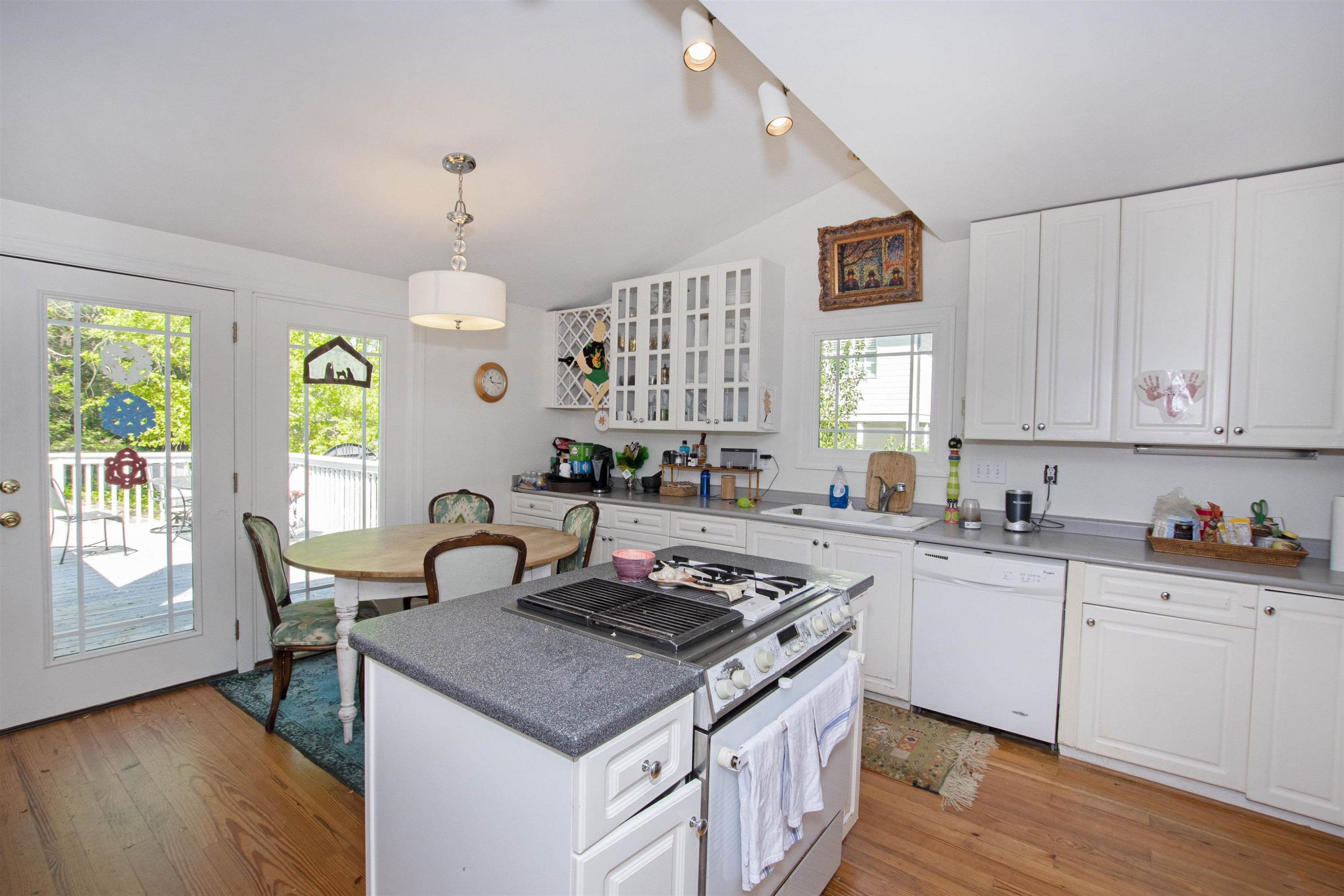 2610 Dover Road Raleigh, NC 27608 - Photo 13 of 20 a kitchen with granite countertop a stove a sink dishwasher and white cabinets with wooden floor