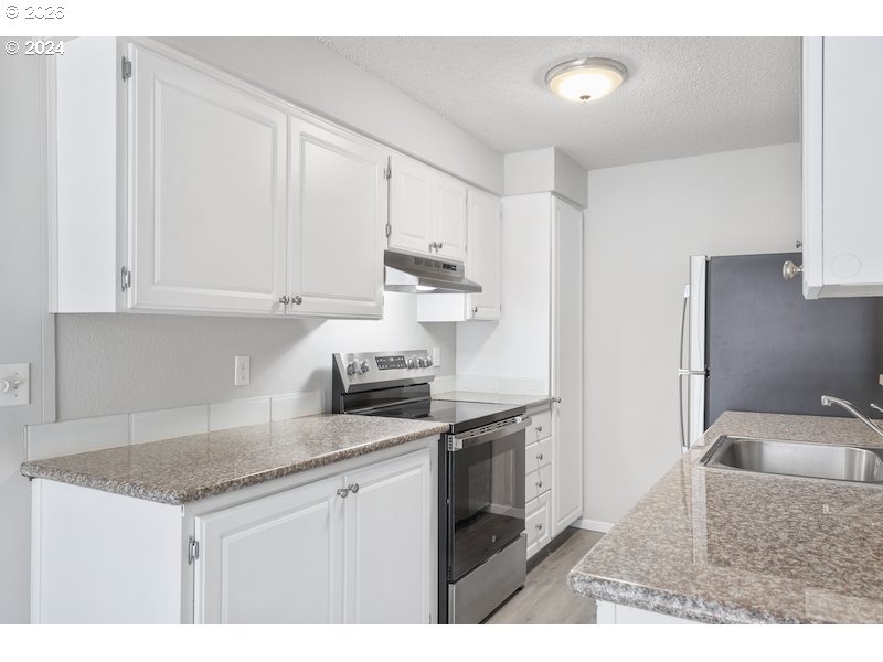2921 Northeast Rene Avenue, Unit 15B Gresham, OR 97030 - Photo 21 of 22 a kitchen with stainless steel appliances granite countertop a sink stove and refrigerator