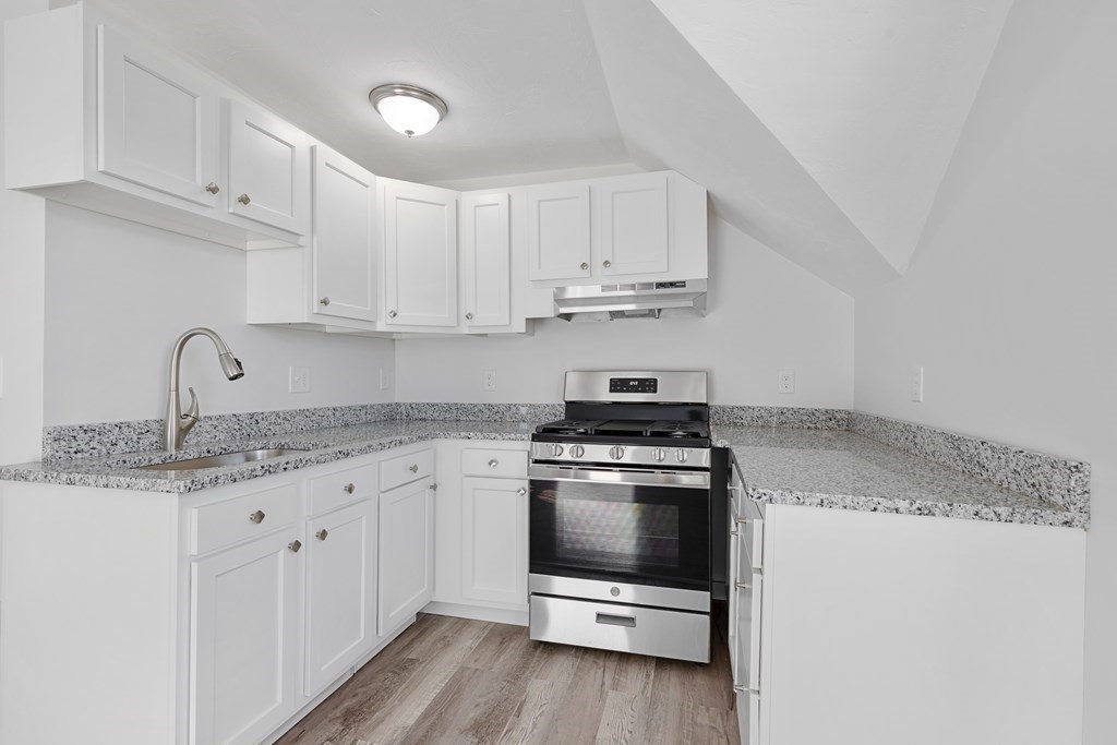 42 Mott Street Fall River, MA 02721 - Photo 12 of 36 a kitchen with granite countertop white cabinets and white appliances