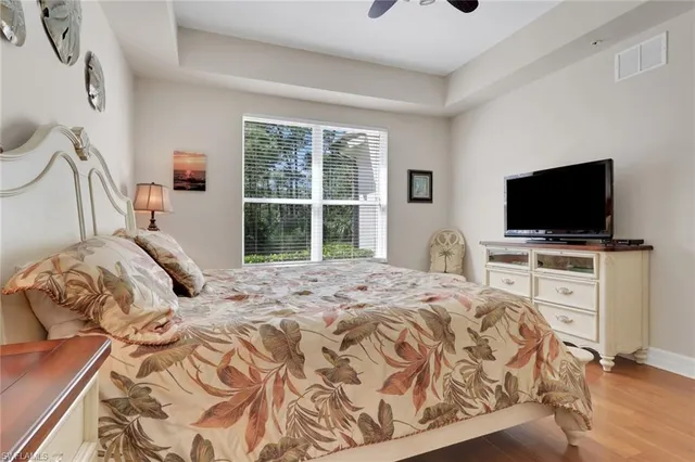 a bedroom with a bed and a flat tv screen on wall