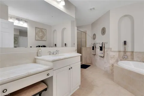a bathroom with a tub sink and mirror