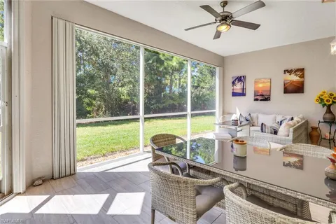 a living room with patio furniture and a floor to ceiling window