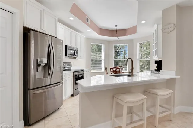 a kitchen with refrigerator a sink and chairs