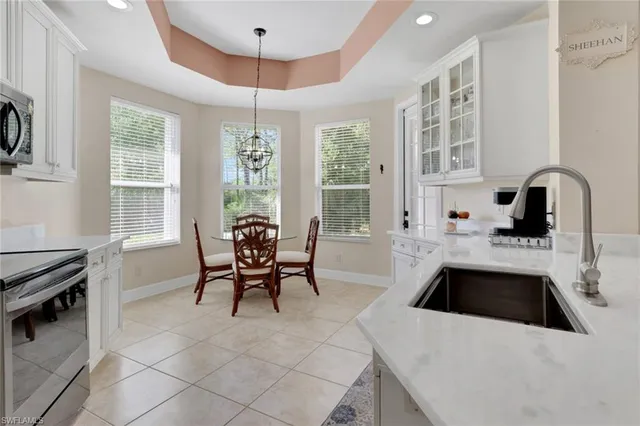 a kitchen with granite countertop a stove a sink and a dining table chair