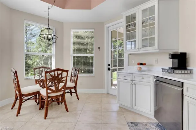 a dining room with furniture a chandelier and window