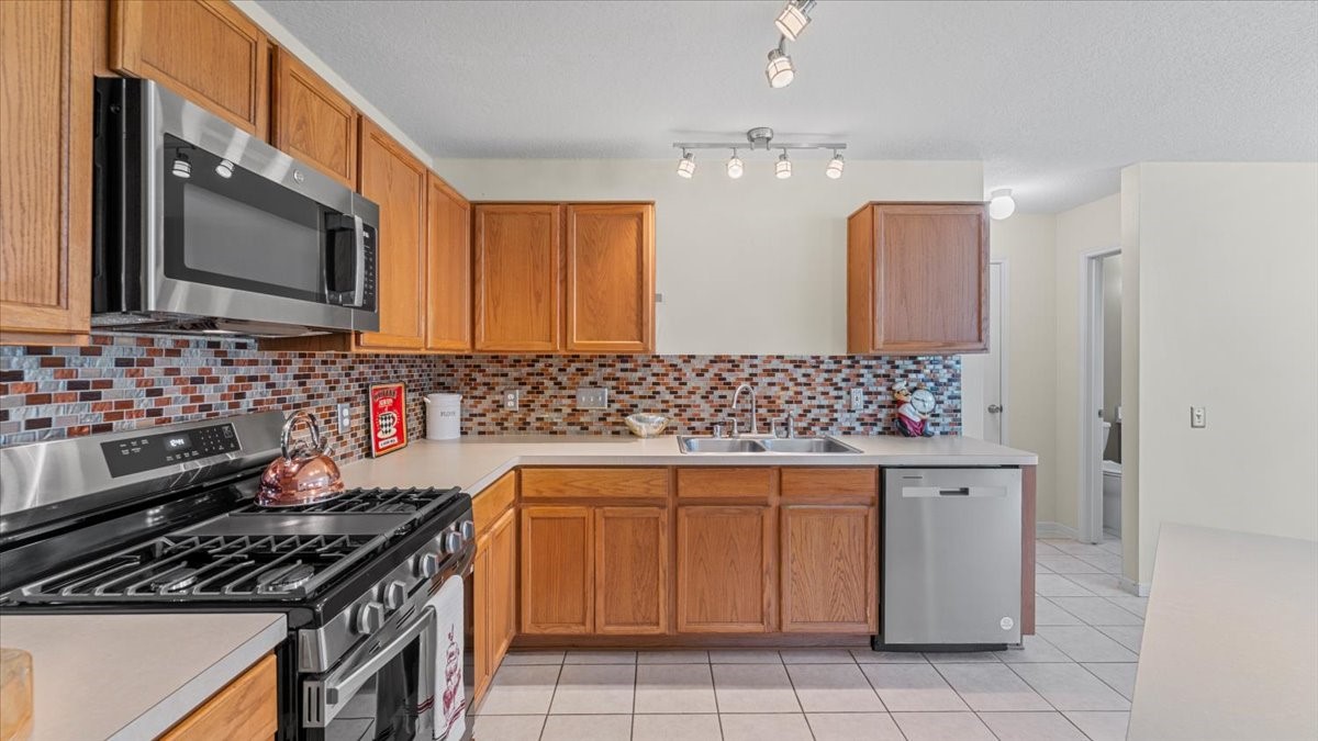 527 Cypresswood Knoll Spring, TX 77373 - Photo 22 of 45 a kitchen with stainless steel appliances a sink stove and cabinets
