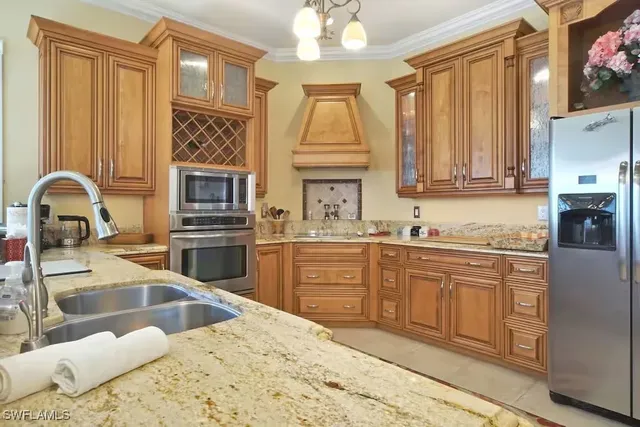 a kitchen with granite countertop a stove a sink and a microwave