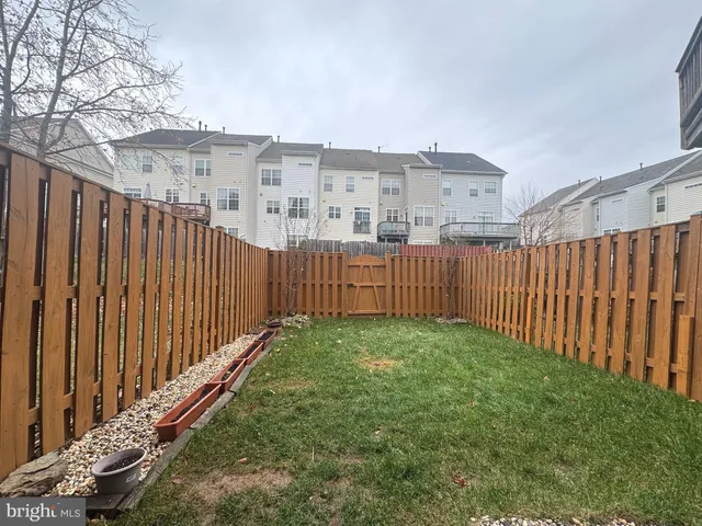 a view of a backyard with wooden fence