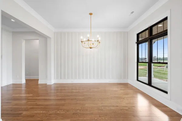 a view of empty room with window and wooden floor