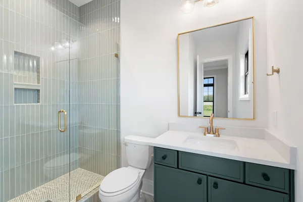 a bathroom with a sink toilet a mirror and shower