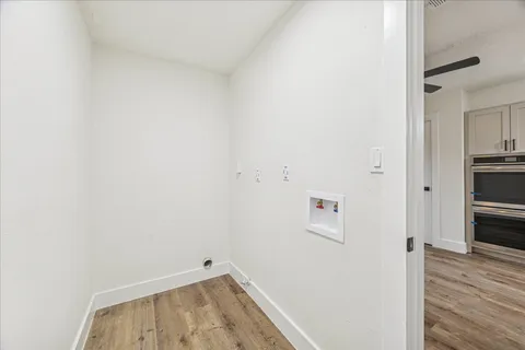 a view of storage and utility room with wooden floor