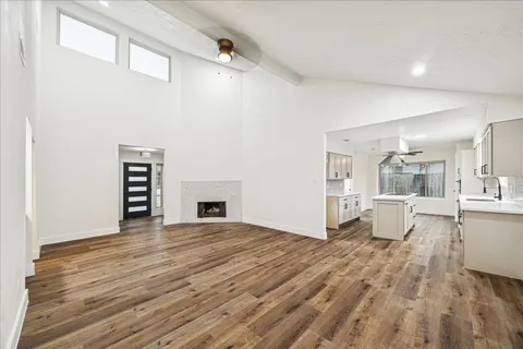 a view of a big room with wooden floor and windows