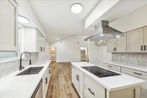 a kitchen with stainless steel appliances a sink stove and cabinets