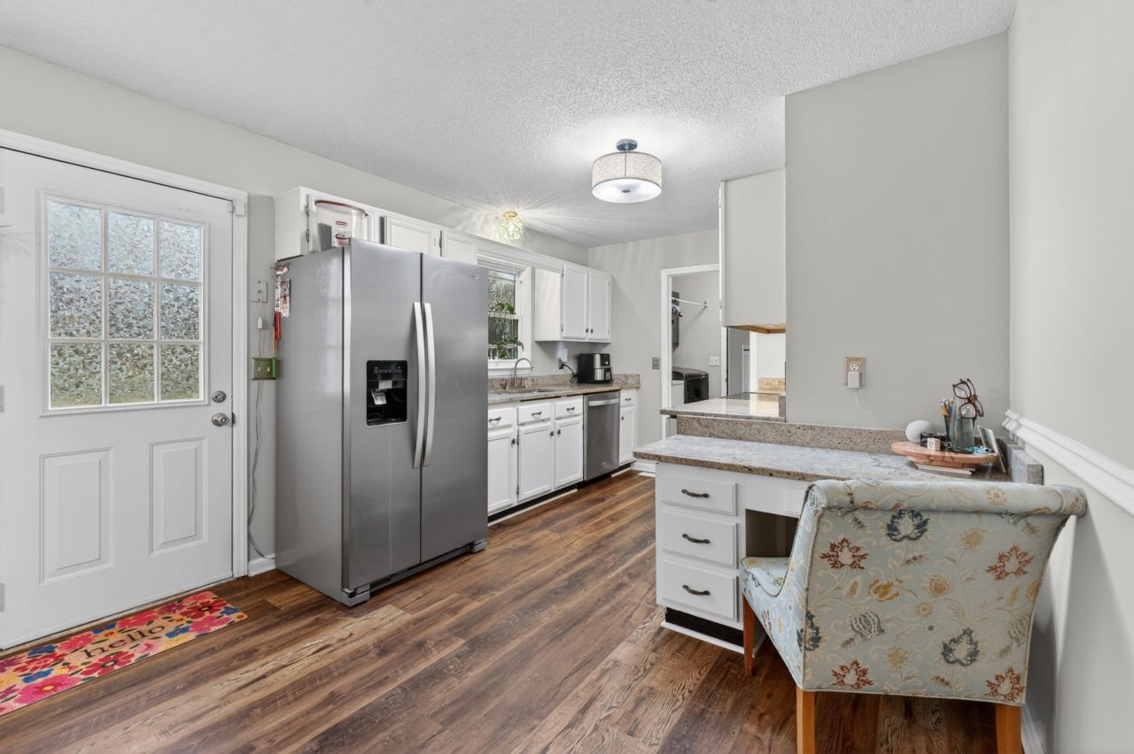 3740 Nicklaus Way Murfreesboro, TN 37128 - Photo 12 of 48 a kitchen with granite countertop a refrigerator a sink dishwasher a stove and white cabinets with wooden floor