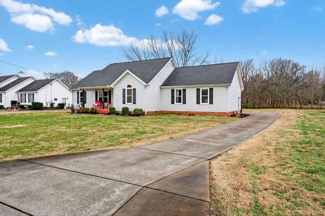 a view of a house with backyard and sitting area