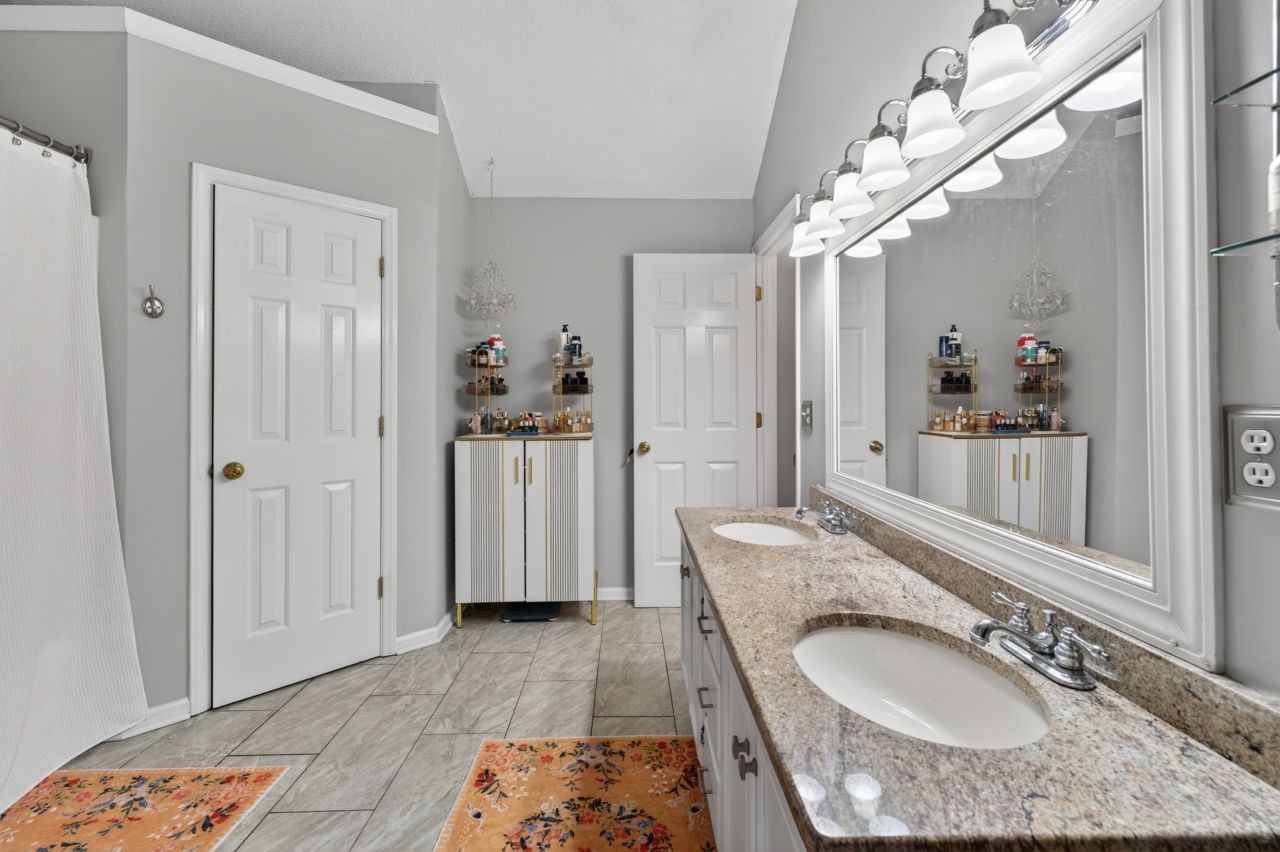 3740 Nicklaus Way Murfreesboro, TN 37128 - Photo 29 of 48 a bathroom with a granite countertop sink a mirror a vanity and shower