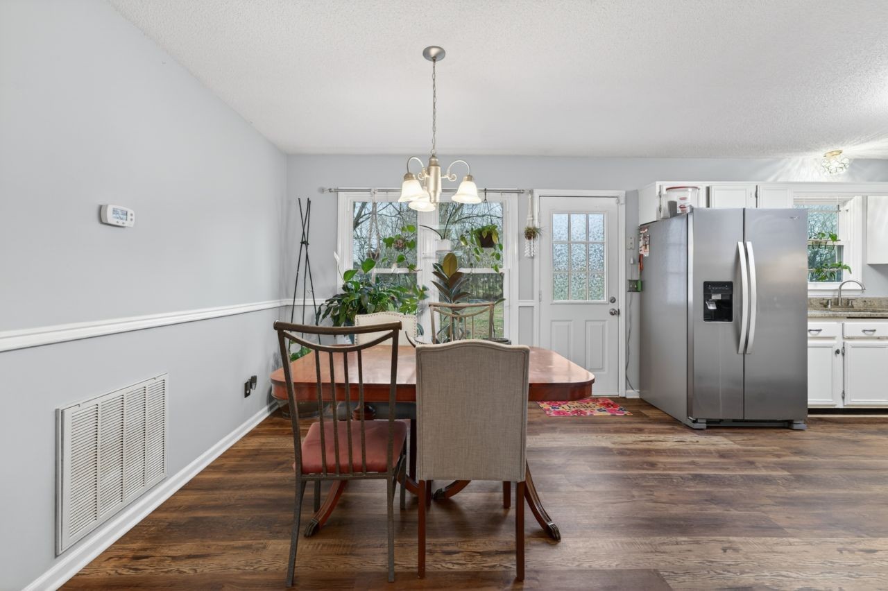 3740 Nicklaus Way Murfreesboro, TN 37128 - Photo 9 of 48 a dining room with furniture a chandelier and wooden floor