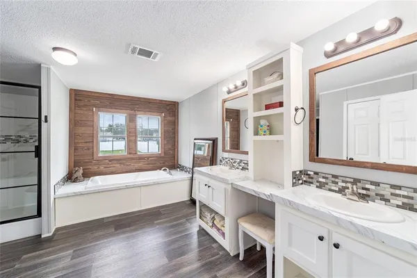 a bathroom with a tub sink and mirror
