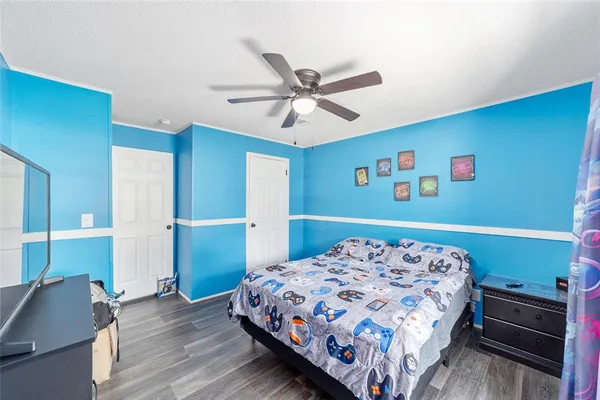a bedroom with a bed and a dresser with wooden floor